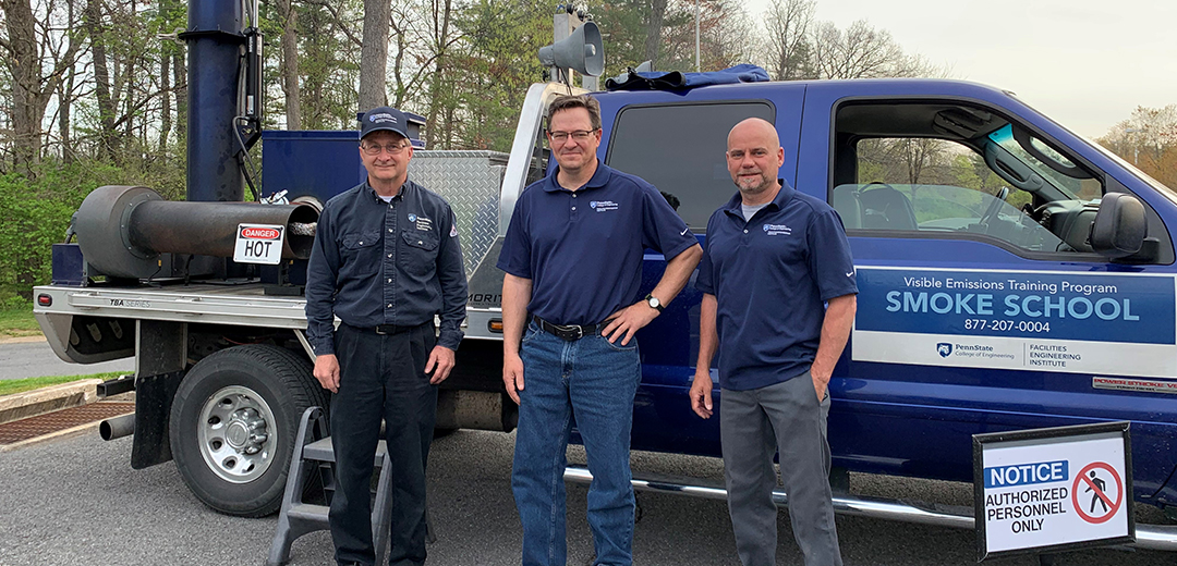 three people standing front of the Smoke School truck