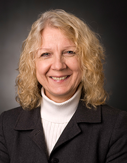 headshot of female with blond hair wearing a black blazer