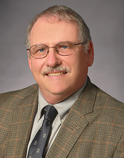 headshot of man wearing a suit