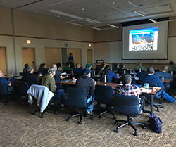 men in classroom with presentation on a screen