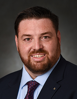 headshot of man wearing a suit